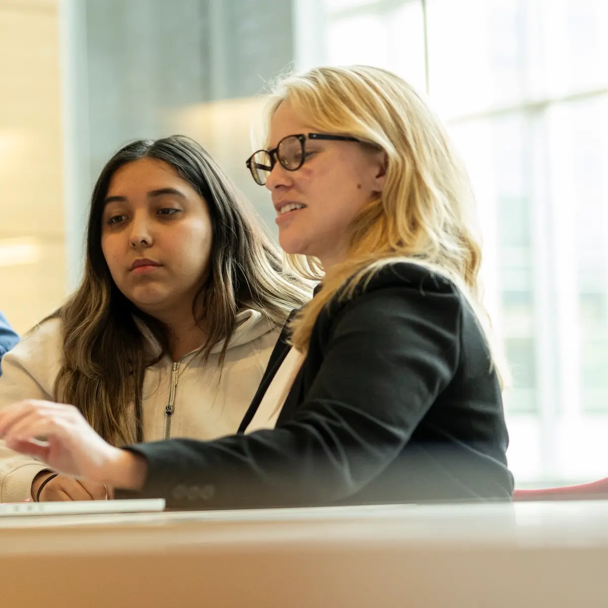 A CHTC research computing facilitator working with a researcher at a laptop