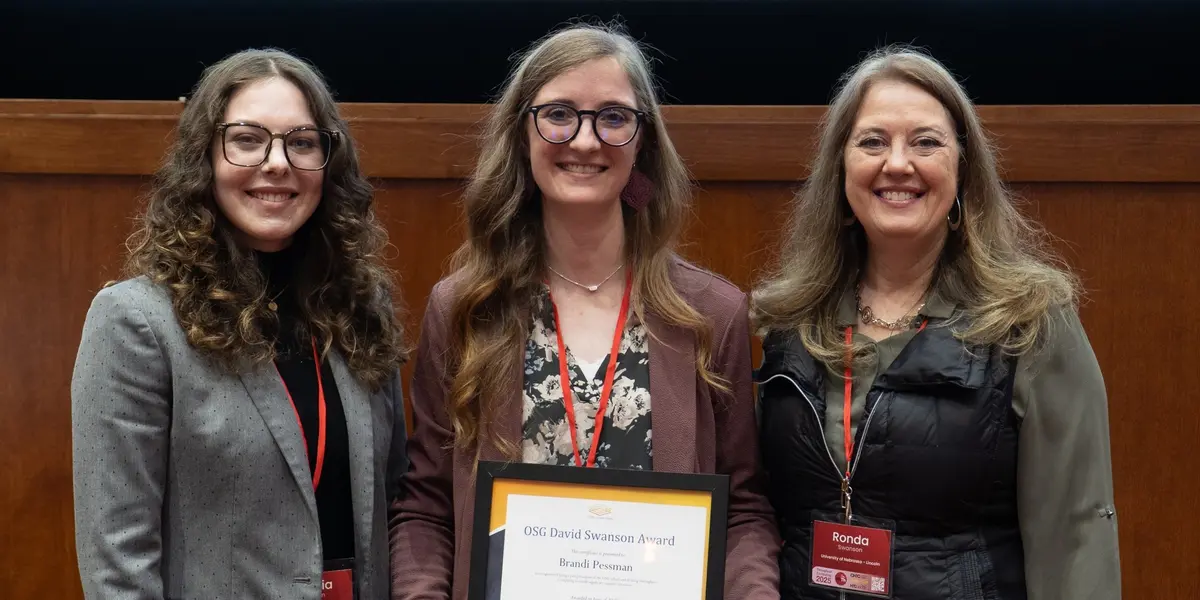 Brandi Pessman (center) receives the OSG David Swanson Award from Sophia (left) and Ronda Swanson (right).